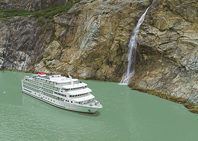American Cruise Line Sailing Past a Waterfall